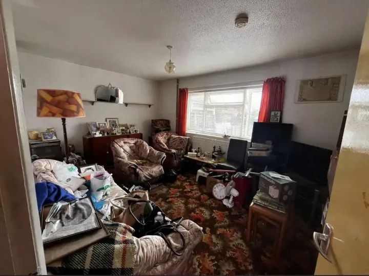 Before house clearance showing a property filled with furniture, household items and debris awaiting removal